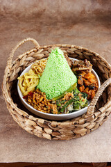 Fototapeta na wymiar Nasi Tumpeng Pandan is dome shape pandan green rice with various side dish.