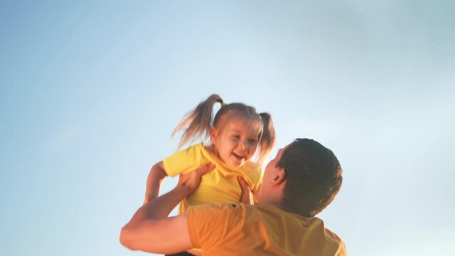 father throw up his daughter. parent play with baby a kid in park silhouette in blue sky. happy family kid dream concept. father throw his daughter up of sun silhouette. happy family in the park