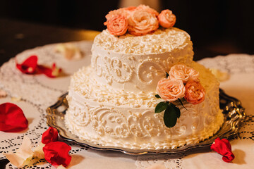 White creamy cake decorated with rosebuds.