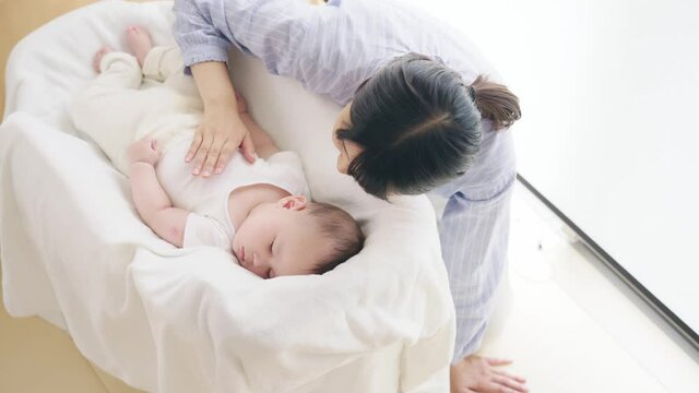 眠る赤ちゃんを見守る女性　スローモーション