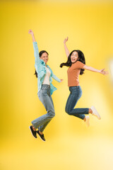 excited two asian woman happy smile jump up celebrate success with raise hands