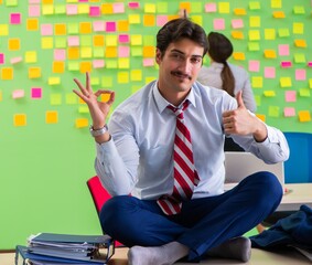 Man and woman in the office with many conflicting priorities in