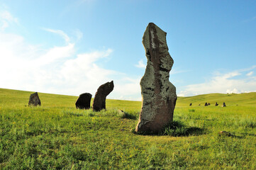 Huge stone menhirs in ancient burial places in the center of a picturesque hilly valley.