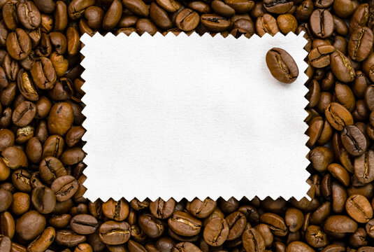 coffee beans frame. White napkin on the background of coffee beans, free space for your text on the coffee beans.