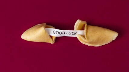 a stopmotion of a fortune cookie cracking and showing a prophecy, saying good luck - Powered by Adobe