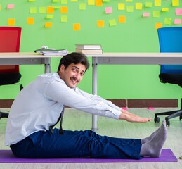Man in the office with many conflicting priorities doing exercis