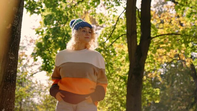 Fall outfit model shushing people in the woods being flirty