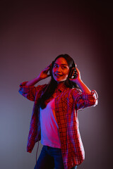 beautiful woman listening to music while standing wearing headphones dancing