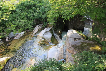 段差のある岩場を滑らかに流れる川、滝