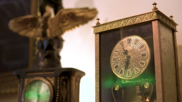 pull focus to luxurious antique watch clocks with interesting patterns design green light streak on a glass cinematic smooth motion drama thriller horror mysterious