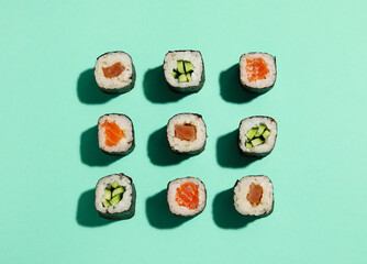 Delicious cucumber and salmon maki sushi on color background © Pixel-Shot