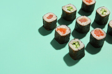 Delicious cucumber and salmon maki sushi on color background, closeup © Pixel-Shot