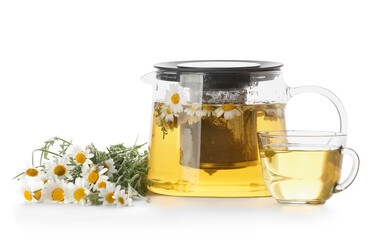 Teapot and cup of tasty tea with chamomile flowers on white background