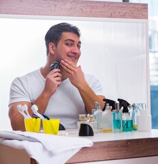 Young handsome man shaving in the morning