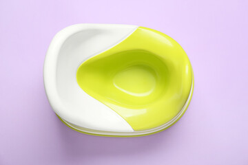Green and white potty on lilac background