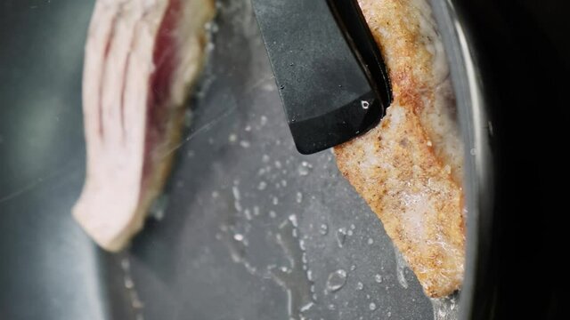 Close-up of the chef flips the fish in a frying pan. Fish cooking concept. Vertical video
