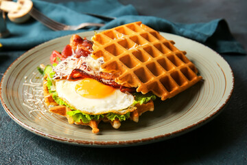 Plate with tasty Belgian waffles and vegetables on dark background, closeup