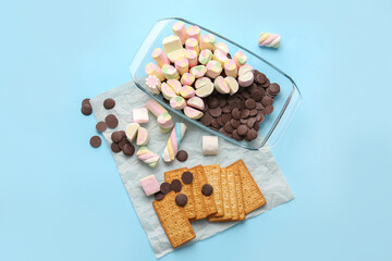 Ingredients for preparing S'mores dip on blue background