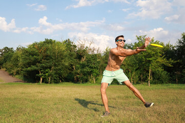 Young man playing frisbee in park