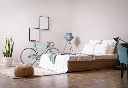 Interior of modern bedroom with bicycle and pouf © Pixel-Shot