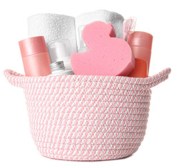 Basket with towels, bath accessories and sponge on white background