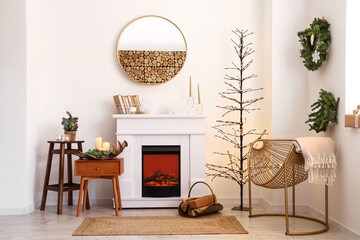 Electric fireplace and stylish armchair in room decorated for Christmas
