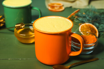 Cup of healthy turmeric latte on table, closeup