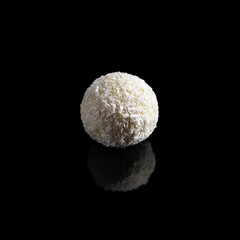 Coconut truffle isolated on a black background.