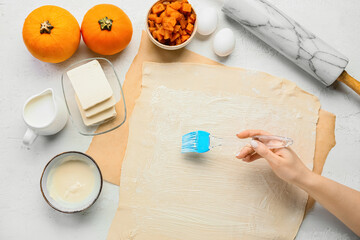 Woman cooking pumpkin strudel on light background