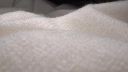 Cozy sheep wool cream-colored fabric texture in macro. Handcraft knitting woolen sweater. Soft textile abstract background. Winter fashion clothing industry. Christmas home comfort and cosiness