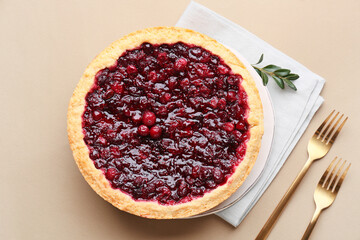 Plate with tasty homemade lingonberry pie on color background