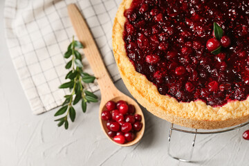 Metal stand with tasty lingonberry pie on light background, closeup