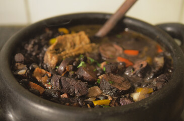 Cooking feijoada on a wood stove