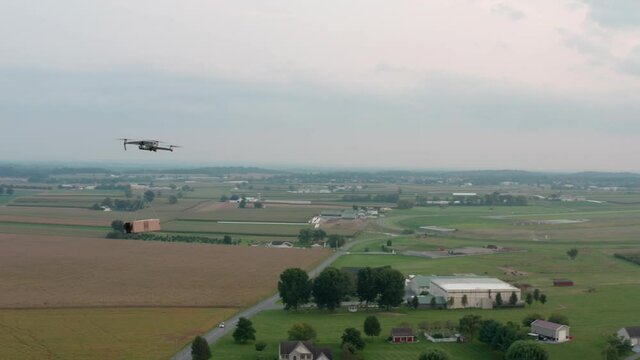 Transportation logistics theme. Aerial of drone flying, carrying package to deliver.