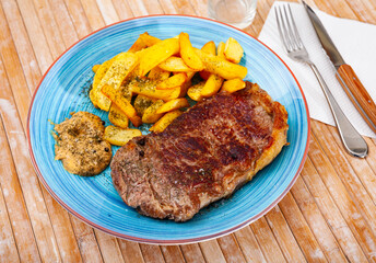 Delicious beef entrecote with fries potatoes closeup