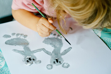 Little creative toddler girl painting with finger colors koala bear. Active child having fun with drawing animals at home, in kindergaten or preschool. Education and distance learning for children © Irina Schmidt