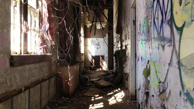 walk through a scary hallway full of debris in an abandoned sanitorium