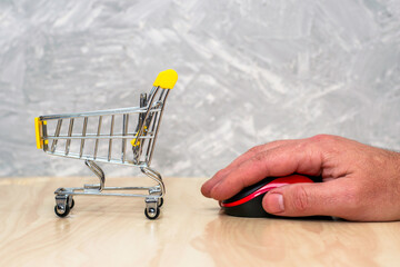 shopping cart and hand with computer mouse online business concept