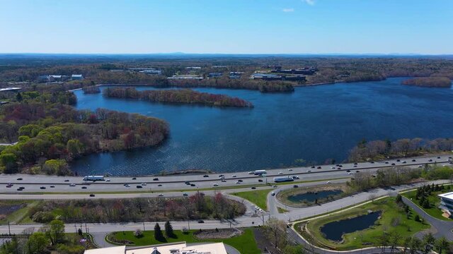 Flying over Interstate Highway 95 I-95 and Cambridge Reservoir in spring in city of Waltham, Massachusetts MA, USA. 