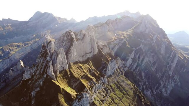 Aerial flyover alongside Schaefler ridge in Appenzell, Switzerland with side view of the cliffs of Alpstein