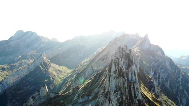 Aerial flyover alongside Schaefler ridge in Appenzell, Switzerland with side view of Alpstein cliffs and Altenalpt&uuml;rm
