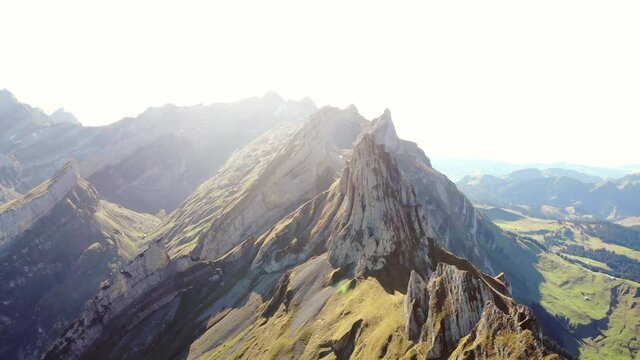 Aerial flyover over Schaefler ridge in Appenzell, Switzerland with the lush slopes in vibrant green underneath the sunshine