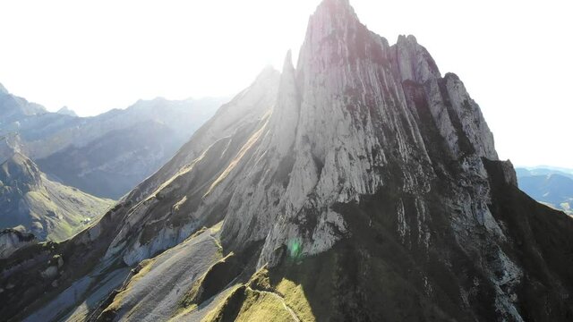 Aerial flyover away from Altenalpt&uuml;rm over Schaefler ridge in Appenzell, Switzerland with view of Alpstein peaks in daylight