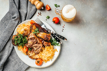 Pork knuckle with beer and sauerkraut. Traditional dish in German cuisine schweinshaxe. banner, menu, recipe place for text, top view