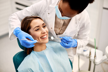 Young happy woman during dental procedure at dentist's office. - obrazy, fototapety, plakaty