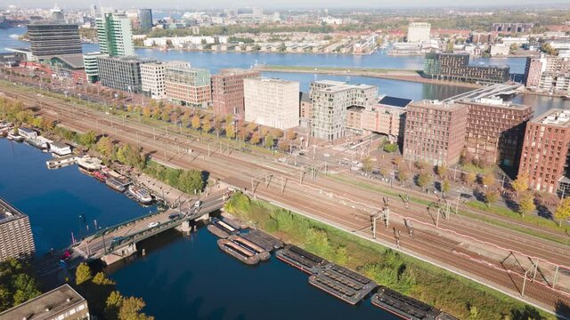 Aerial hyperlapse of an intersection on the Piet Hein kade in Amsterdam. tram, traffic, train and automobiles passing through.