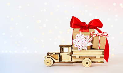 Wooden car carrying gifts against the background of defocused lights