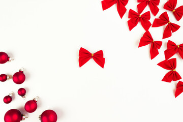 frame of Christmas red balls and bows on a white background with one red bow in the center.