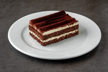 Gourmet Italian dessert tiramisu on dark stone table