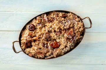 Risotto ai funghi, mushroom rice dish, shot from above on a rustic wooden table